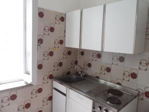 a kitchen with a sink and a tiled wall at Case Vacanze Valdilago in Bolsena +18 photos