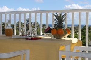 a table with a bowl of fruit on a balcony at Résidence Tropicale in Le Moule