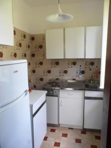 a kitchen with white cabinets and a white refrigerator at Case Vacanze Valdilago in Bolsena