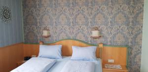a bedroom with two beds and a wall with wallpaper at Sportpension Alpenrose in Schladming