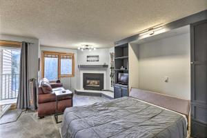 Un dormitorio con una cama y una chimenea. en Cozy Ski-InandOut Winter Park Studio with Hot Tubs!, en Winter Park