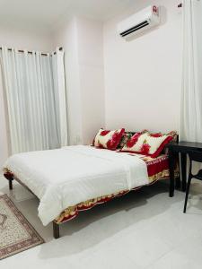 a bedroom with a bed and a desk in a room at ADDA Guest House in Kota Bharu