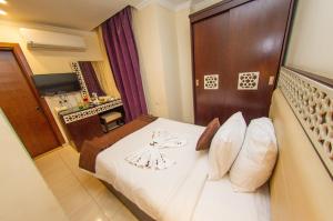 開羅的住宿－金字塔谷精品酒店，酒店客房设有一张白色大床和一间浴室。
