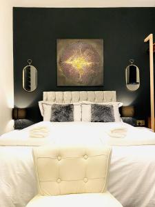 a bedroom with a large white bed with black walls at Duke and Duchess Apartments and Rooms - Private in Room Hot Tub Suites in London