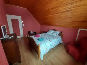 科爾的住宿－L'éloge de la Nature，一间卧室设有一张床和木制天花板