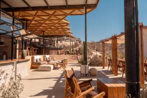 a patio with chairs and tables and a pavilion at Encuentro Guadalupe in Valle de Guadalupe