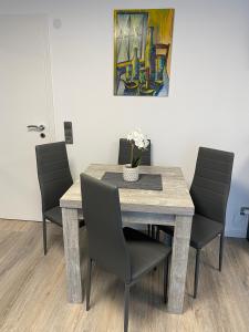 een eettafel met stoelen en een schilderij bij 1,5 Zimmer Apartment in S-Bahn Nähe, 35 qm, max 4 Pers, zentral, private Terasse, Internet 250 MBit in Gärtringen