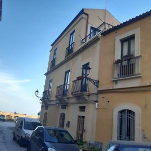 a building with cars parked in front of it at Talete Palace in Siracusa