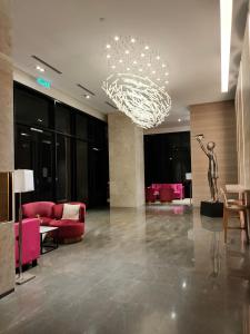 un vestíbulo con muebles de color rosa y una lámpara de araña en Ai Smart Home , Bangsar South en Kuala Lumpur