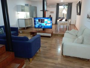a living room with a blue couch and a tv at House near Barcelona/F1 circuit in Montmeló