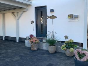 un porche con macetas delante de una puerta en Appartement Meerzeit - a62529 en Laboe