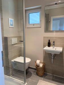 La salle de bains est pourvue de toilettes et d'un lavabo. dans l'établissement Appartement Meerzeit - a62529, à Laboe