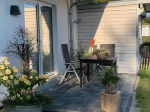 une terrasse avec une table, des chaises et des plantes dans l'établissement Appartement Meerzeit - a62529, à Laboe