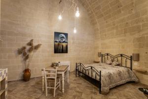 ein Schlafzimmer mit einem Bett und einem Tisch in einem Zimmer in der Unterkunft Antichi Orizzonti in Matera