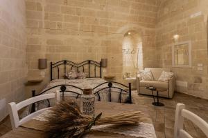 ein Schlafzimmer mit einem Bett und einem Tisch mit einer Flasche in der Unterkunft Antichi Orizzonti in Matera