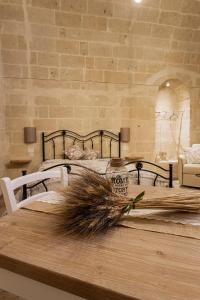 ein Schlafzimmer mit einem Bett und einem Tisch mit einer Pflanze darauf in der Unterkunft Antichi Orizzonti in Matera