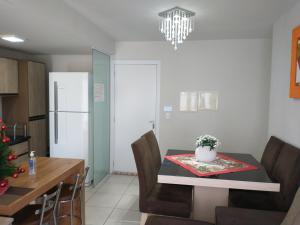 a kitchen and dining room with a table with a vase on it at Apto Vista Atlântico com 2 quartos com Ar Cond Wi-Fi TV SMART e Área de lazer in Itapema +40 photos