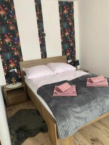 a bedroom with a bed with two towels on it at Apartamenty Otrytturystyka in Ustrzyki Dolne