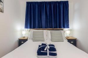 1 dormitorio con 1 cama con cortina azul en 429 Norton Park, en Dartmouth
