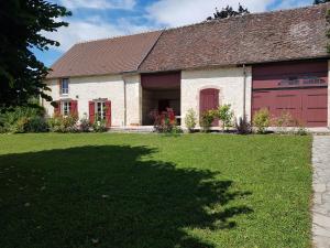 a house with a garage and a grass yard at Les 7 tilleuls - Gîte in Mesland
