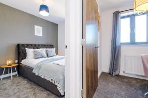 a bedroom with a bed and a window at Rest&Recharge at Waterway House (4 Bedrooms, 7 Beds, 2 Bathrooms, Free parking) in Manchester