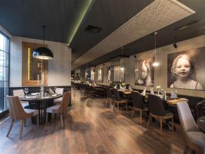 a dining room with tables and chairs and pictures on the walls at Bilek Hotel Kavacık in Istanbul