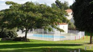 a fence around a swimming pool in a yard at Ternélia Henri IV in Clisson