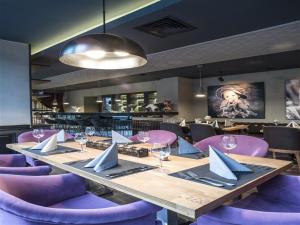 a dining room with a long table and purple chairs at Bilek Hotel Kavacık in Istanbul