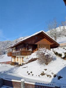 una casa en la nieve con una valla en Ferienhaus Schwab, en Aich