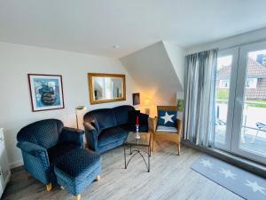Una sala de estar con dos sillas y una mesa. en Ruheoase am Dorfteich für 2-4 Personen, en Wenningstedt