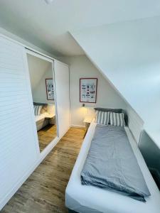 a small bedroom with a bed in a attic at Ruheoase am Dorfteich für 2-4 Personen in Wenningstedt