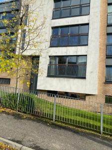 a fence in front of a building at City Centre 2 bedroom apartment, secure parking. in Glasgow