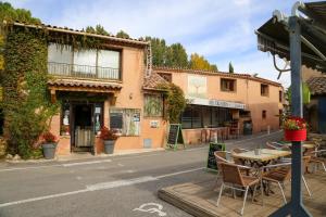 eine Straße mit einem Tisch und Stühlen vor einem Gebäude in der Unterkunft Lou Cigaloun in Saint Antonin du Var