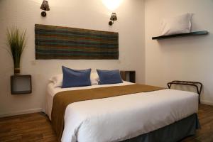 a bedroom with a large bed with blue pillows at HOTEL 3 étoiles NN "LOU CIGALOUN" in Saint Antonin du Var