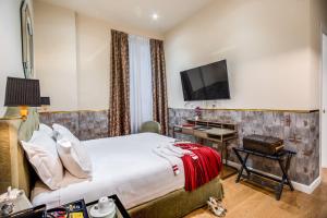 ein Hotelzimmer mit einem Bett, einem Schreibtisch und einem TV in der Unterkunft The Talent Hotel in Rom