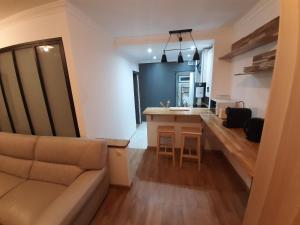 a living room with a couch and a kitchen at Appartement 2 pièces, proche RER, Bus et chateau in Rambouillet