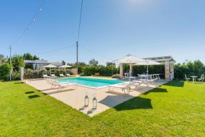 a swimming pool with chairs and an umbrella at DIMORA FEO in Gallipoli