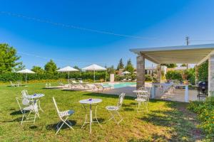 a group of chairs and tables in a yard with a pool at DIMORA FEO in Gallipoli