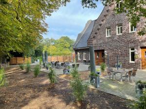 un bâtiment avec des tables et des chaises devant lui dans l'établissement dS Hotel Restaurant Gronau, à Gronau