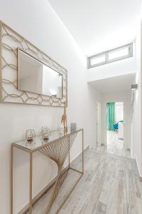 ein Wohnzimmer mit einem Tisch und einem Spiegel in der Unterkunft Deluxe bungalow Perla Del Sur in Adeje + 22 Fotos