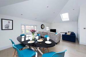 een woonkamer met een zwarte tafel en blauwe stoelen bij Recently redecorated bright and spacious 1BR flat in West London in Londen
