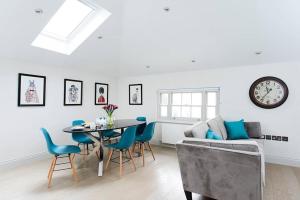 a living room with a table and chairs and a clock at Recently redecorated bright and spacious 1BR flat in West London in London