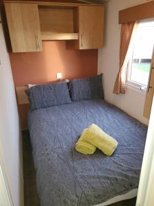 a small bedroom with a bed in a caravan at Parkdean Kessingland Beach Holiday Chalet in Benacre
