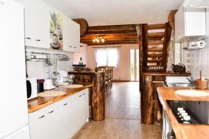 a kitchen with white cabinets and wooden walls at Casa de sub Horă in Zărneşti