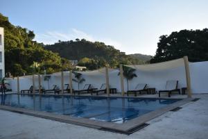 a swimming pool with chairs and aermottermottermott at MALAKI in Los Ayala