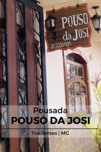 un panneau sur le côté d'un bâtiment avec une porte dans l'établissement Pousada da Josi - Tiradentes, à Tiradentes