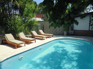uma piscina com espreguiçadeiras e uma mesa em Aimara apartamentos y habitaciones em Santa Rosa de Calamuchita