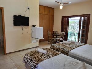 ein Hotelzimmer mit 2 Betten und einem TV in der Unterkunft Pousada Appaloosa in Águas de Lindóia