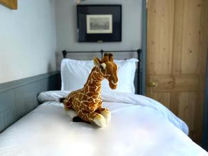 una jirafa de peluche sentada encima de una cama en 27 Brighton Guesthouse, en Brighton & Hove