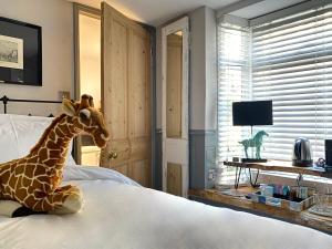 una jirafa disecada sentada en una cama en un dormitorio en 27 Brighton Guesthouse, en Brighton & Hove
